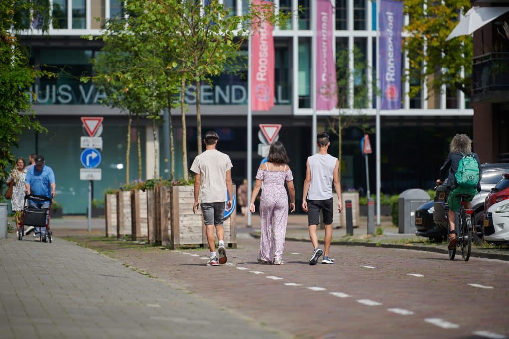 Een groep van drie personen op weg naar het HUIS van Roosendaal